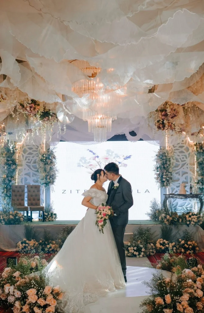 Bride and groom celebrating their wedding with elegant floral arrangements, chandeliers, and stylish reception décor in Davao City.