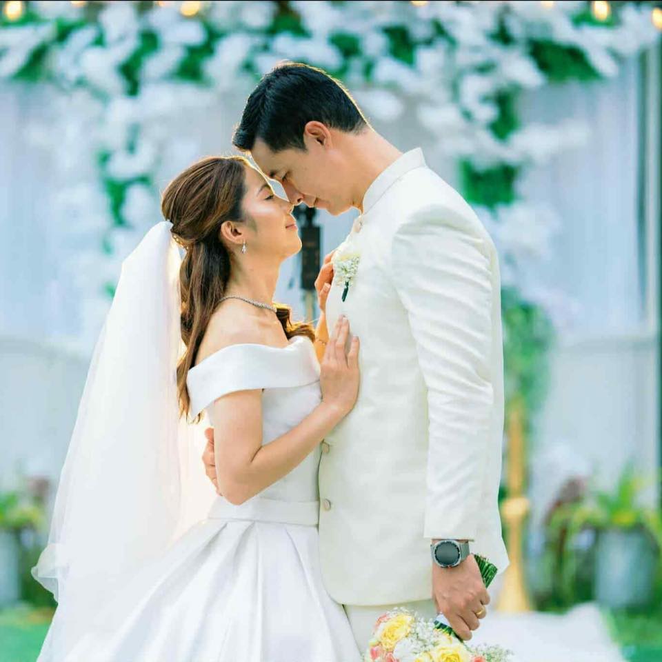 Bride and groom celebrating their wedding with elegant floral arrangements, chandeliers, and stylish reception décor in Davao City.